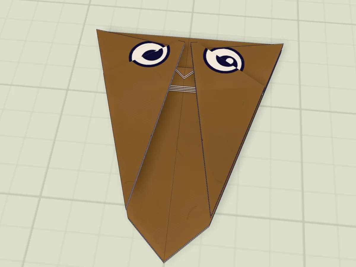 Chouette en papier avec bec triangulaire, ailes rabattues et yeux dessinés