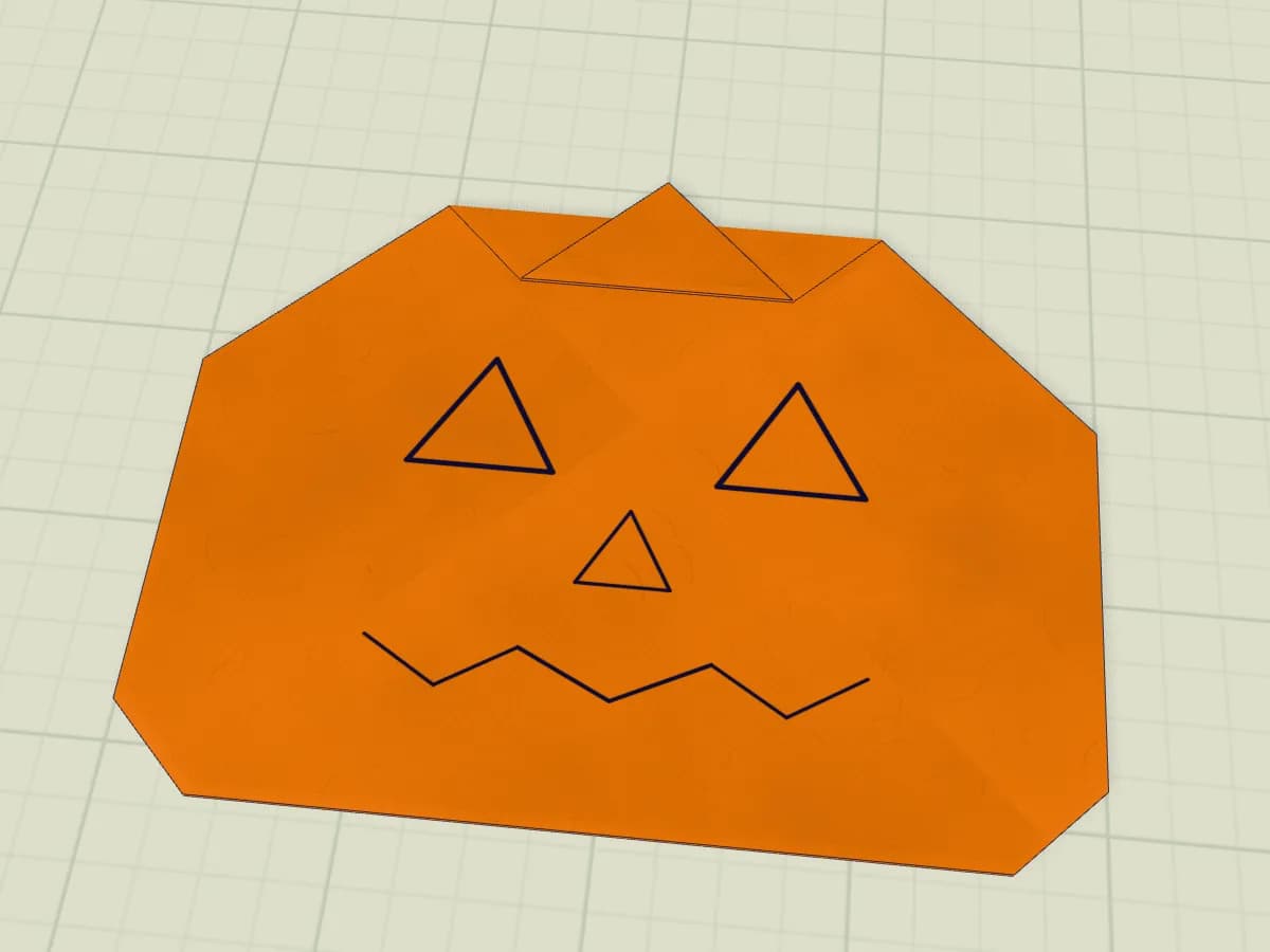 Citrouille en papier avec yeux triangulaires et bouche en zigzag