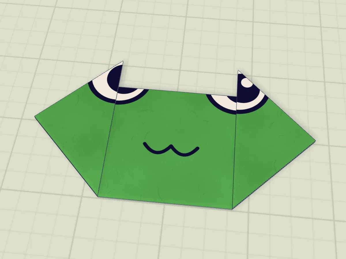 Tête de grenouille en papier aux yeux relevés et à la bouche souriante